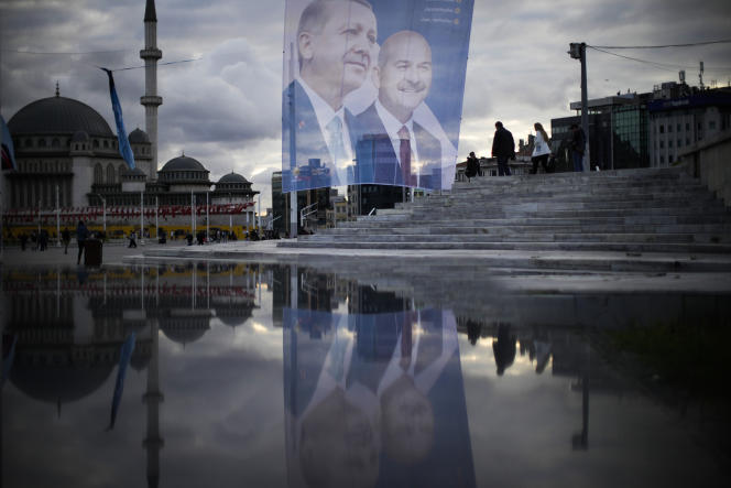 مشاة يمشون أمام لافتة ضخمة للرئيس التركي ومرشح الرئاسة من تحالف الشعب رجب طيب أردوغان في ميدان تقسيم بإسطنبول في 10 مايو 2023. 