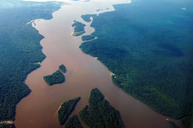 Aerial view showing the Essequibo River running in a section of the Amazon rainforest in the Potaro-Siparuni region of Guyana, taken on September 24, 2022. Despite the dispute with Guyana, the Esequibo region is a destination of migration from Venezuela. Guyana defends a limit established in 1899 by an arbitration court in Paris, while Venezuela claims the Geneva Agreement, signed in 1966 with the United Kingdom before Guyanese independence, which established the basis for a negotiated solution and ignored the previous treaty. But the Guyanese government is promoting a process in the International Court of Justice (ICJ) to ratify the current borders and put an end to the dispute. (Photo by Patrick FORT / AFP)