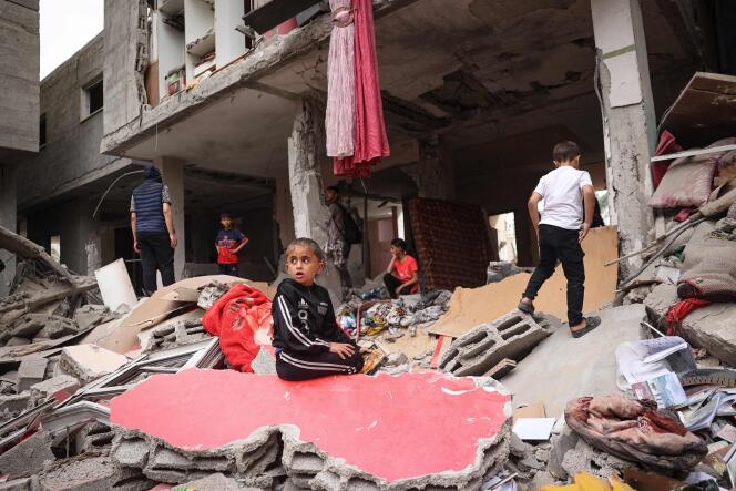 أطفال فلسطينيون بين أنقاض منزل دمره قصف إسرائيلي في رفح جنوب قطاع غزة في 27 أبريل 2024.