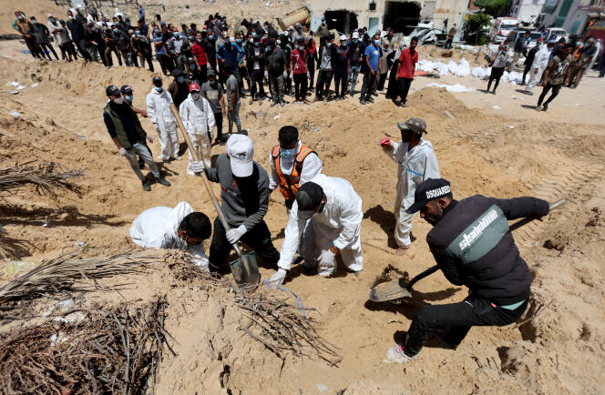 رجال الإنقاذ الفلسطينيون يقومون باستخراج الجثث التي يُزعم أنها اكتشفت في أراضي مستشفى ناصر في خان يونس، جنوب قطاع غزة، في 21 أبريل 2024. 
