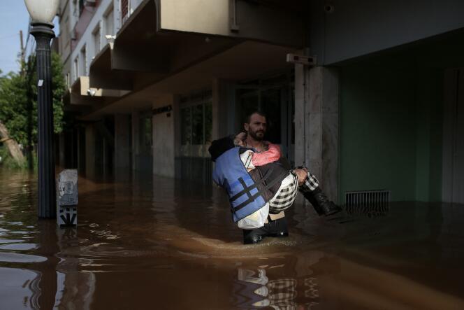 متطوع ينقذ امرأة من منطقة غمرتها الفيضانات في بورتو أليغري، ولاية ريو غراندي دو سول، البرازيل، 8 مايو 2024.